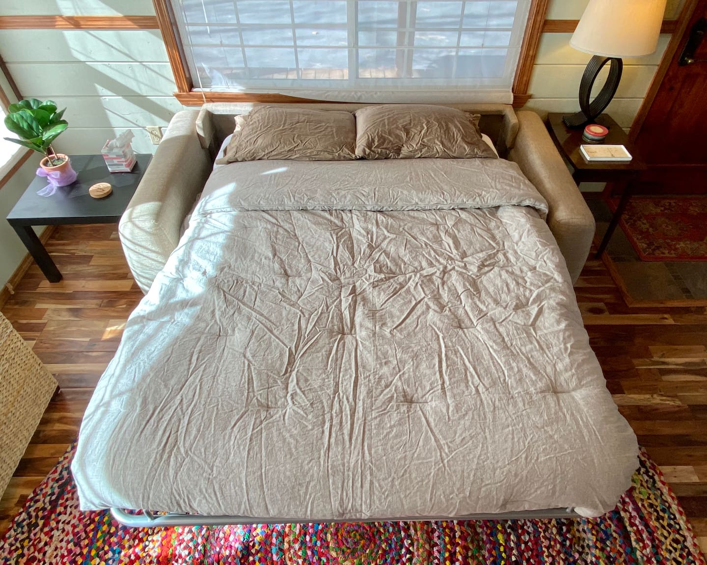 The queen mattress unfolds from the couch and bedding is available in the wicker chest